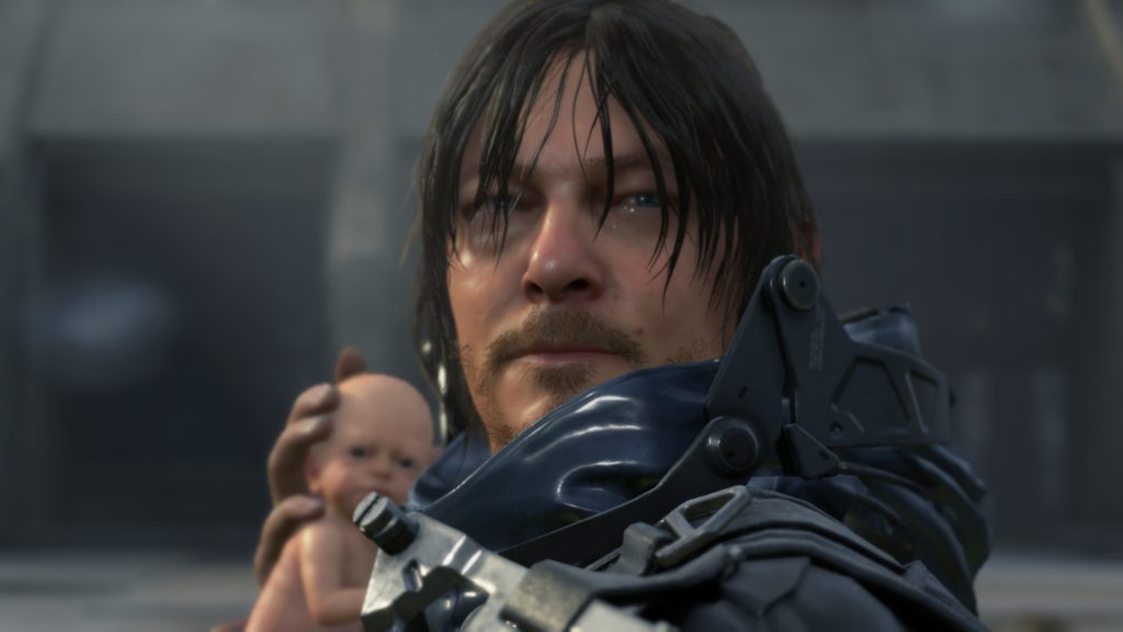 A scruffy man clutches a baby outside a large concrete building.