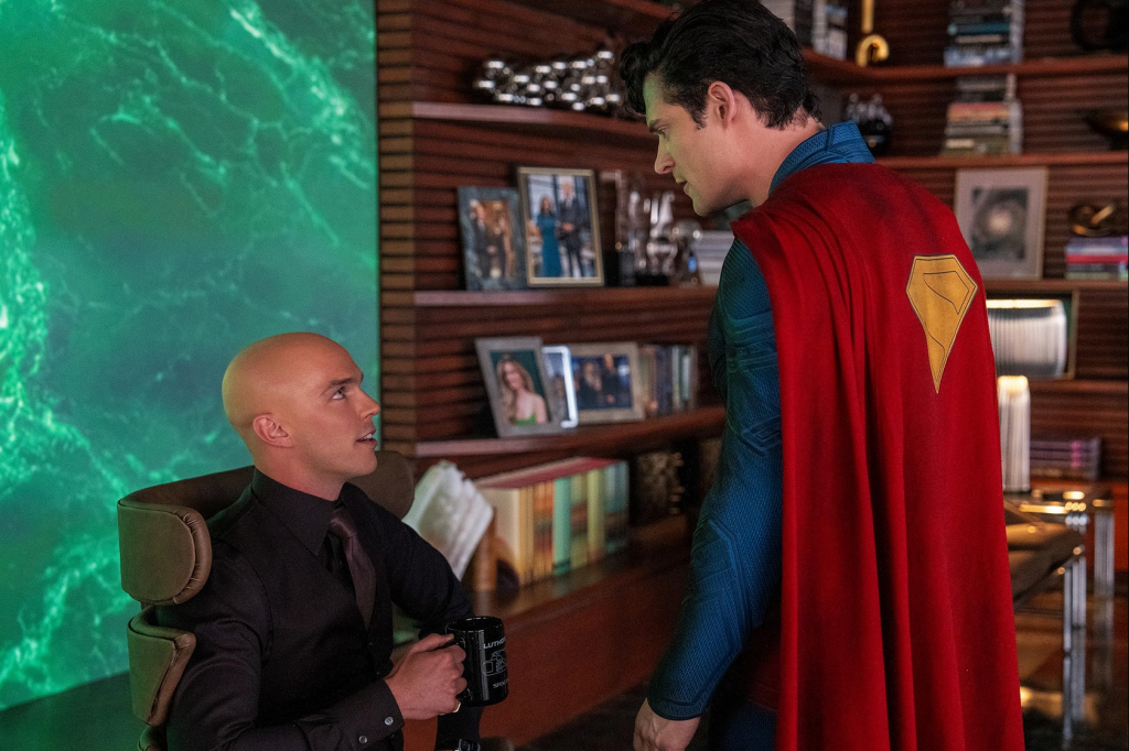 Superman looms over Lex Luthor, sat at a desk coyly drinking from a mug. Credit: Warner Bros.