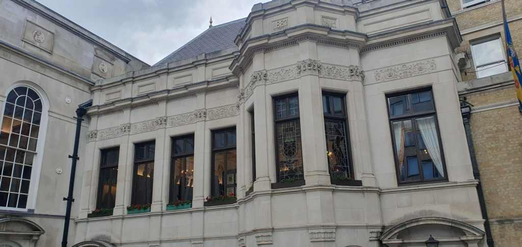 A building front with light carved stone and stained glass windows