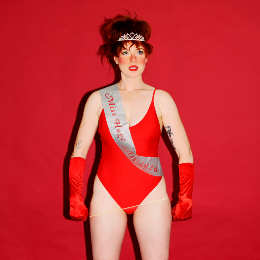 Australian comedian Frankie McNair, wearing a sash labelled "Miss Huge Ass 2026".